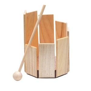 Instrument de percussion en bois avec des pièces rectangulaires et une baguette en bois.